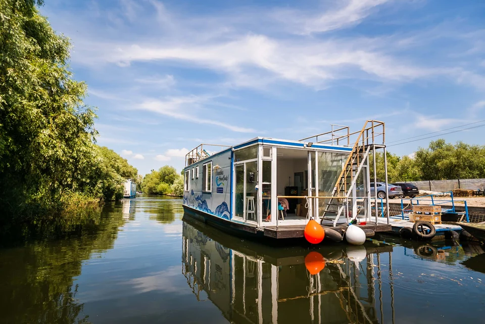 Houseboat cu balustradă și scară exterioară, pe apă