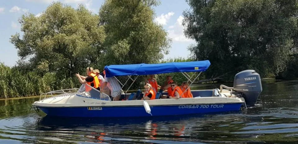 Barcă albastră cu pasageri, în mers pe apă Barcă albastră cu pasageri, în mers pe apă