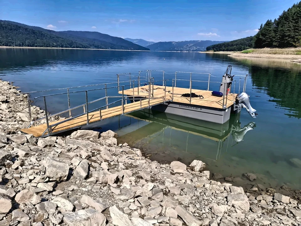 Catamaran cu punte deschisă și balustradă pe lac