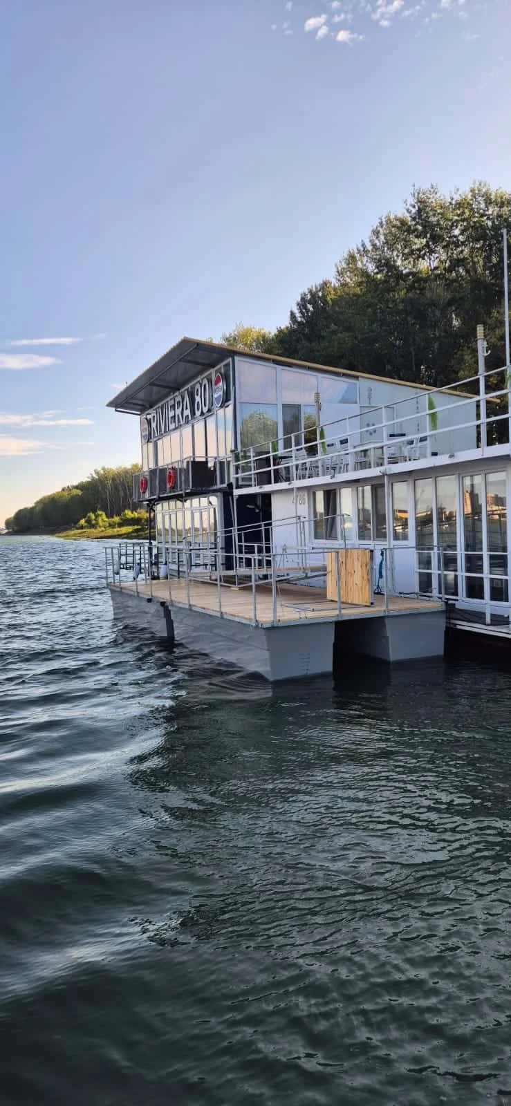 Ponton cu balustradă lângă o clădire, vedere de pe apă